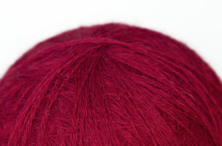 close-up of a ball of woolen yarn in red color, fur textureの写真素材