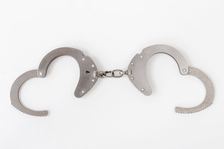 opened handcuffs in the form of hearts, on a white isolated backgroundの写真素材