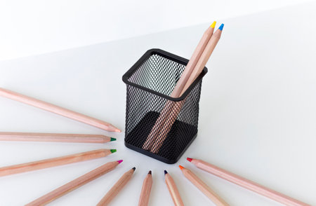 a pair of pencils in a glass, blue and yellow, symbolize the colors of the flag of Ukraine, on a white backgroundの写真素材