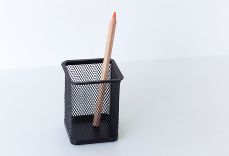 orange pencil in a stationery cup on a white backgroundの写真素材