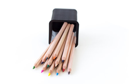 multi-colored pencils fell out of a fallen glass, on a white backgroundの写真素材