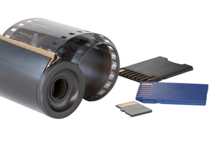 Micro SD card against vintage roll film in reel, on isolated backgroundの写真素材