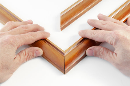 close-up of human hands assembling a wooden frame, on isolated whiteの写真素材