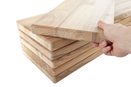 a hand pulls a wooden plank from a stack, steps for a spiral staircase, on an isolated white backgroundの写真素材