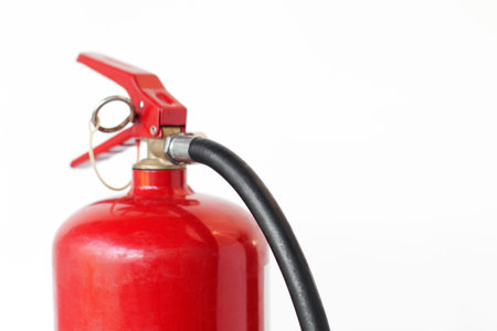 Fire extinguisher used to put out fires during an emergency, on an isolated white background, close-upの写真素材