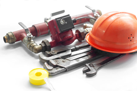 heating system, bypass with circulation pump and plumbing tool, gas wrench and work helmet, on white backgroundの写真素材
