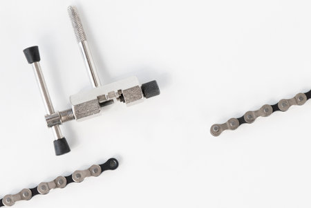 dismantled bicycle chain, chain link puller, tool, on a white isolated backgroundの写真素材