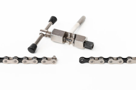 dismantled bicycle chain, chain link puller, tool, on a white isolated backgroundの写真素材