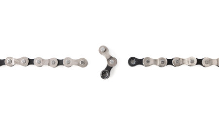 dismantled link of a bicycle chain, the weakest link, a broken chain, on a white isolated backgroundの写真素材