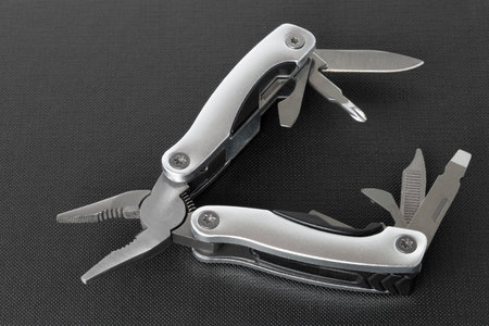 Multi tool with expanded tools and pliers on a black backgroundの写真素材