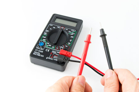 Digital multimeter in hands, Power tools and equipment, Electrical appliance on an isolated white background.の写真素材