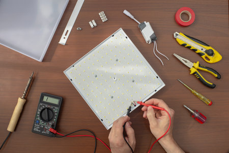 top view of a table with tools, where an Electrical Technician is repairing an LED lamp, close-upの写真素材
