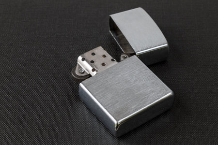 Windproof petrol lighter in metal style, on a dark textured backgroundの写真素材