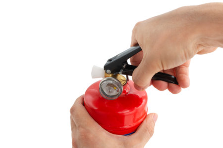 Concept of handling fire extinguishers, the hand squeezes on the fire extinguisher lever, on an white background, close-upの写真素材