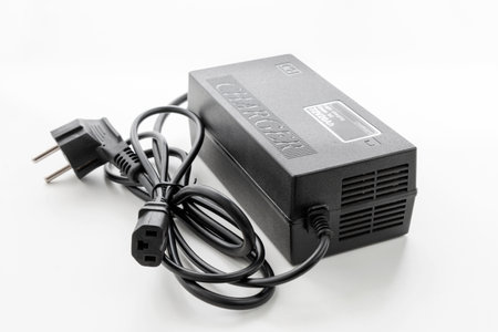 Electric scooter charger, AC - DC adapter on isolated white backgroundの写真素材