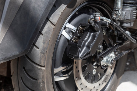electric rear motorcycle wheel, brake disc and caliper, close upの写真素材