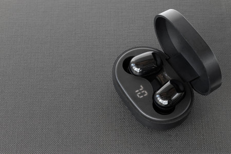 Wireless headphones in a mockup case on a black background with space for text. Black headphones in...