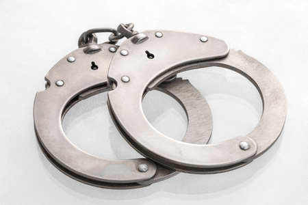 Pair of steel handcuffs close up, Silver metal handcuffs on white