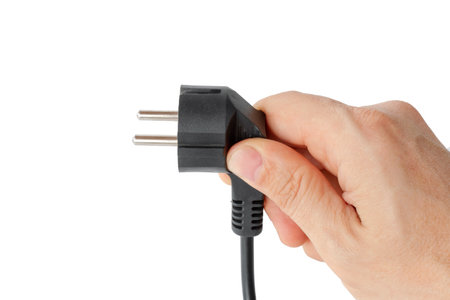 electric cable with a plug in a man's hand, close-up, isolated.