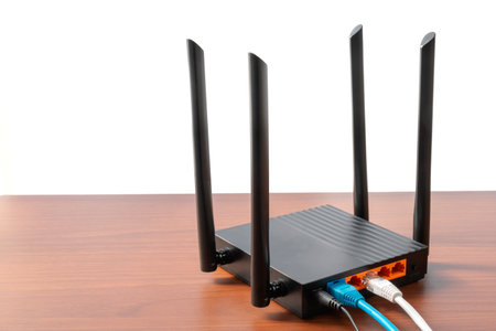 Modern wireless wi-fi router at wooden table indoors on isolated white, with copy space. Wireless...