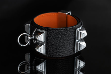 Black leather bracelet with spikes, rings, pyramids. An accessory for rockers, bikers, metalheads, goths and punks. Steampunk style. Close-up subject photography.の写真素材
