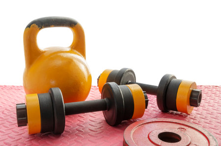 Old kettlebell and dumbbells on the floor with weights for fitness training. Healthy lifestyle concept. Home gym. Space for text. Partially cut out, on isolated white.の写真素材