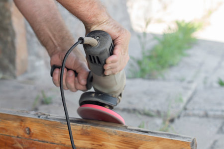 man polishing a board with a manual grinder, close-upの写真素材