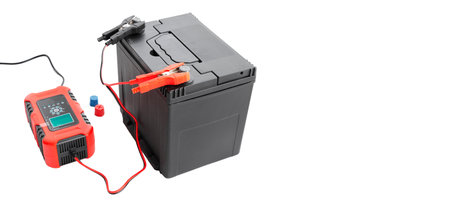 recharging AGM car battery with automatic charger, cut out, isolated background. Battery restoration and care concept. With copy space.の写真素材