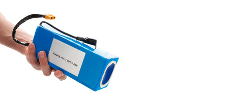 Hand holding battery from electric bicycle. Lithium-ion industrial high current batteries. With copy space, cut out.の写真素材