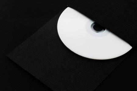 White CD, DVD, Blu Ray, Optical Disc printed side up in black envelope, on black backgroundの写真素材