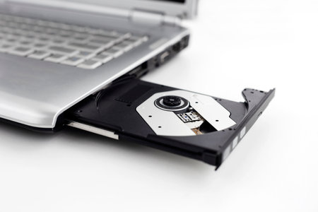 Laptop with open CD DVD drive, Closeup image isolated on a white backgroundの写真素材