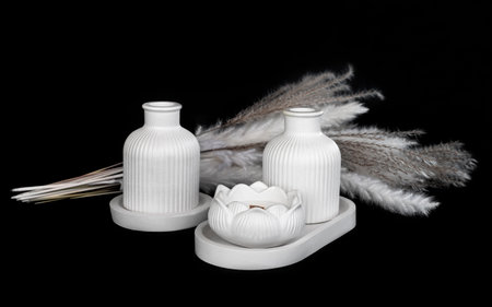 composition of white plaster flowerpots and aroma candles, on isolated black, handmade conceptの写真素材