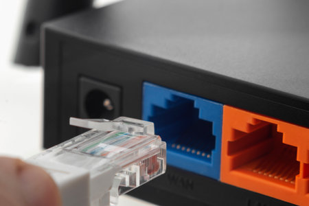 Close-up of connection to internet provider network, connecting ethernet cable to wireless router.