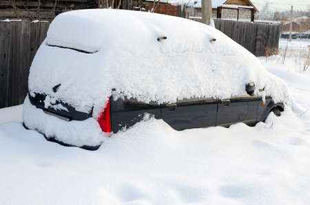 Car covered with snow in the winter snowfallの写真素材