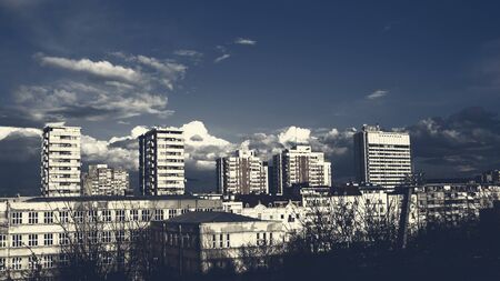 Urban old buildings with white fluffy clouds in the blue skyの写真素材