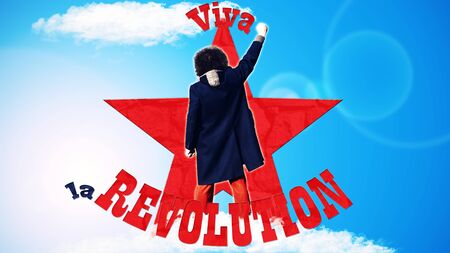 Man standing with fist pointed up on blue background with red star and text that spells Viva la...