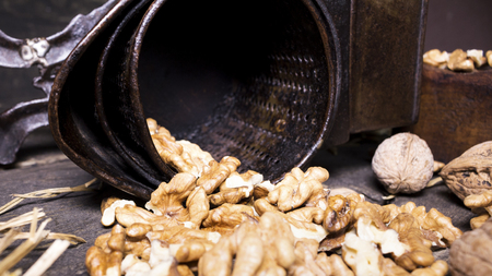 Wallnuts and hand walnuts grinderon a wooden surfaceの写真素材