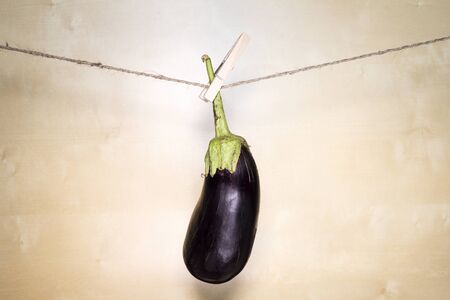 Eggplant On Wooden Background Hanging On A Ropeの写真素材