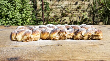 Strudel on a Wooden Table Resting All Sprinkeld With Shugar Powderの写真素材