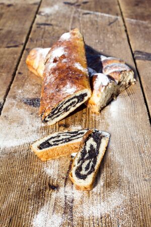 Strudel with poppy seeds on a Wooden Table All Sprinkeld With Shugar Powderの写真素材