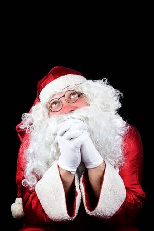 Santa Claus in the Christmas Night Praying Isolated On Black Backgroundの写真素材
