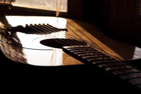 Acoustic Guitar In Music Studio Close up. Shined By The Sun At The Golden Hour
