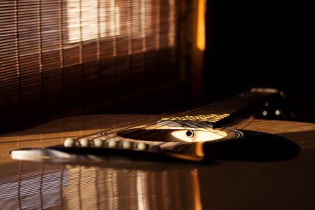 Acoustic Guitar In Music Studio Close up. Shined By The Sun At The Golden Hour