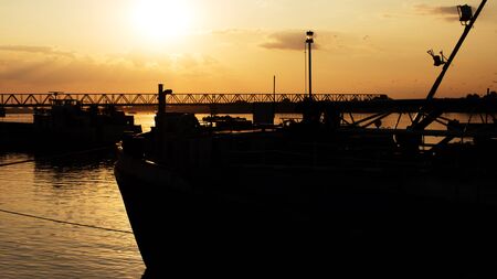 Beautiful Golden Sunset with Ships and Bridge Silhouettes At The River Danube in Belgrade Serbiaの写真素材