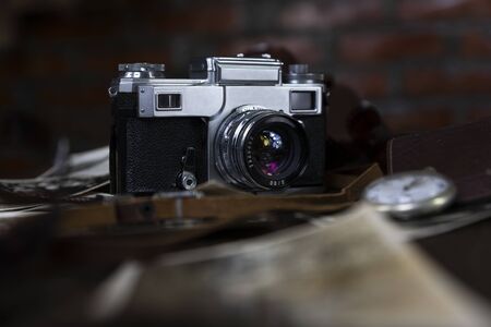 Vintage film camera and old photographs on a rustic surface の写真素材