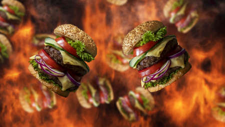 Hamburgers falling with smoke and burning fire in background. Fast food menu promoの写真素材