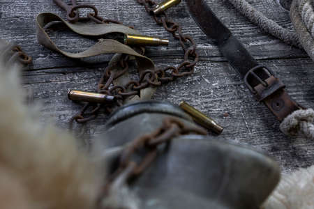 Bullet caings and rusy chain resting on wooden tableの写真素材