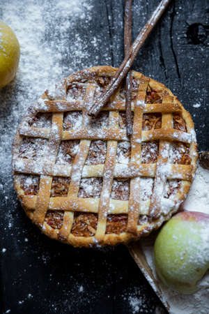 Apple pie with cinnamon on an old textured wooden backgroundの写真素材