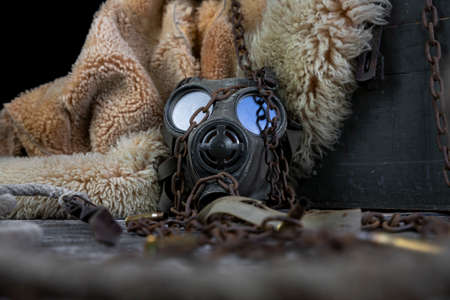 Military gas mask and rusty chain. Apocalyptic concept. Corona virus pandemic preventionの写真素材