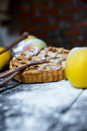 Apple pie with cinnamon on an old textured wooden backgroundの写真素材